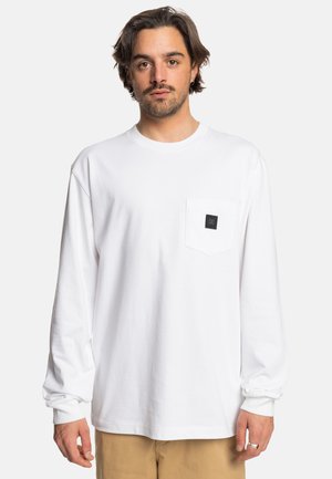 White long-sleeve t-shirt in cotton, featuring a front pocket with a black logo patch, round neckline, and relaxed fit.