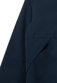 Marinblå långärmad topp med en mjuk textur, med ett lagerdesign och subtila sömnadsdetaljer nära sömmarna.
