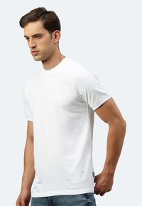 T-shirt bianco a maniche corte con scollo rotondo, realizzato in tessuto morbido. Presenta un'etichetta laterale e una vestibilità comoda.
