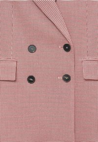 Punavalkoinen houndstooth-kuvioitu bleiseri, jossa on kaksirivinen malli, mustat napit ja kaksi etutaskua. Sileä kangaspinta.