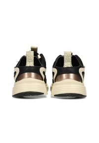 Des chaussures de sport noires avec un dessus texturé, des accents métalliques et des semelles de couleur crème. Présente un onglet de talon texturé en or pour un enfilage facile.