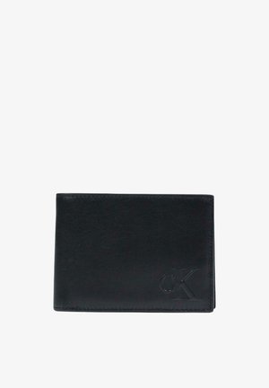 Portefeuille en cuir noir avec texture lisse, design pliable en deux, et logo embossé « CK » sur le devant. Style compact et minimaliste.