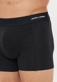 Schwarze Boxershorts aus weichem Material, mit enger Passform, genähten Details und einem elastischen Bund mit dem Markennamen "JACK & JONES."