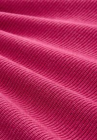 Texturiertes pinkes Gewebe mit einem wellenförmigen Muster, das eine weiche, gerippte Oberfläche zeigt. Die Farbe ist lebhaft und gleichmäßig im Material verteilt.