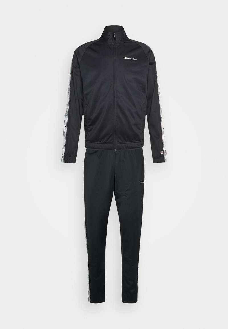 Survêtement noir Champion avec veste zippée et pantalon assorti, avec des bandes blanches du logo le long des manches et des jambes du pantalon.