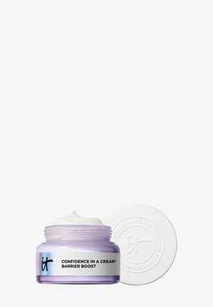 Open lavendelpotje van de "Confidence In A Cream Barrier Boost" moisturizer met witte crème erin en een wit gegraveerd deksel ernaast.
