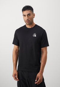 Black cotton t-shirt featuring a small white mountain logo on the left chest. Short sleeves and a crew neckline with a smooth texture.