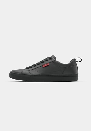Schwarze Low-Top-Sneaker aus glattem Material, mit runder Zehenpartie, Schnürsenkeln, einer strukturierten Sohle und einem kleinen roten Logo.