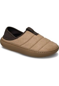 Beżowe buty wsuwane o pikowanej strukturze, z miękkiego materiału na wierzchu oraz brązowej gumowej podeszwie. Wyposażone w pętelkę dla łatwego zakładania.