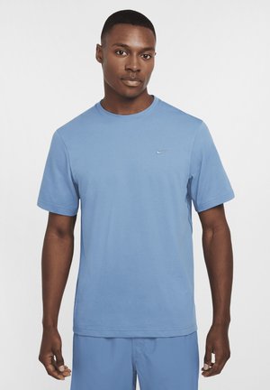 T-shirt bleu clair à col rond fabriqué en tissu lisse et respirant. Manches courtes avec un petit logo Nike blanc sur la poitrine gauche.