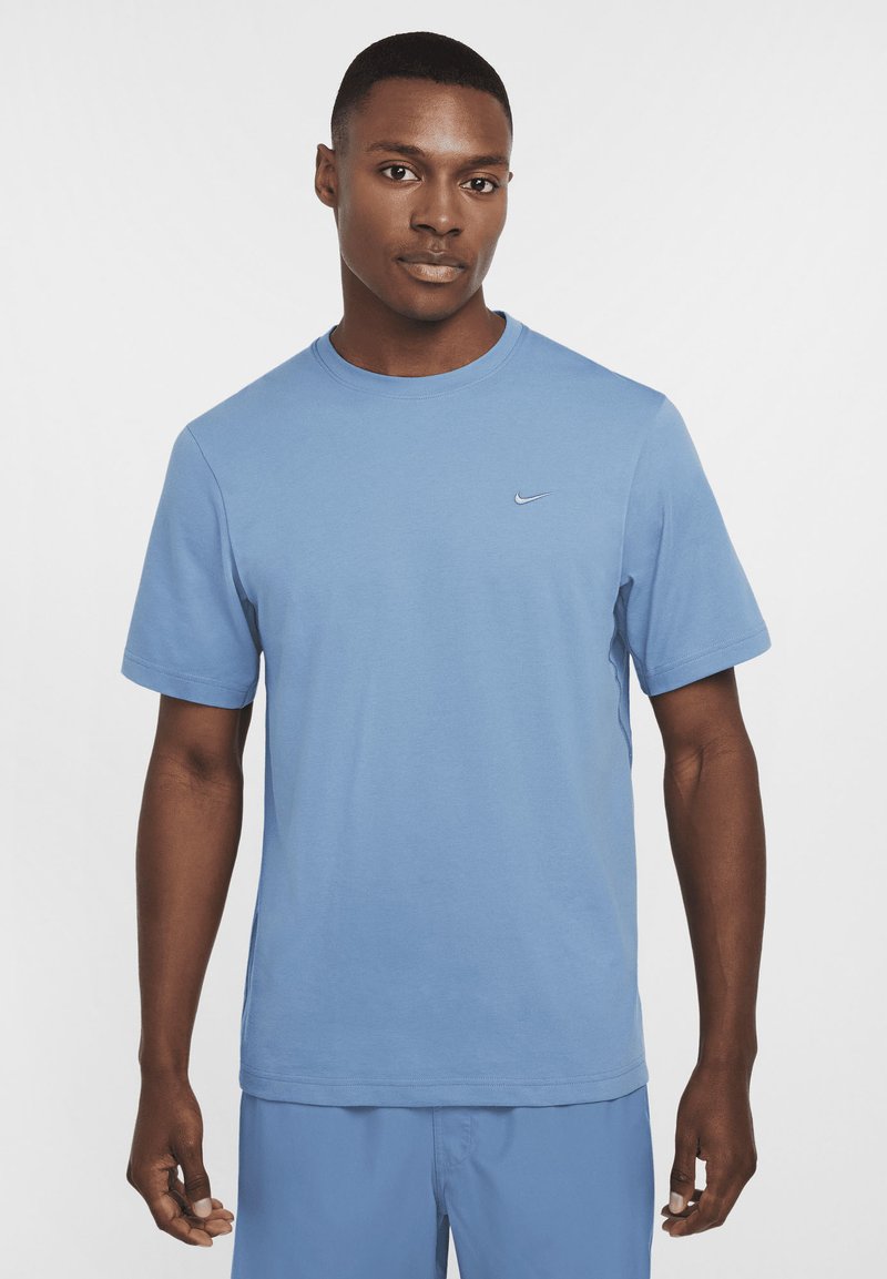 Light blue crew-neck t-shirt made of smooth, breathable fabric. Short sleeves with a small, white Nike swoosh on the left chest.