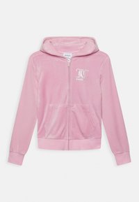Velvet pink zip-up hoodie with a front pocket, long sleeves, and a hood. Features silver "J.C." logo on the left side. Soft texture.