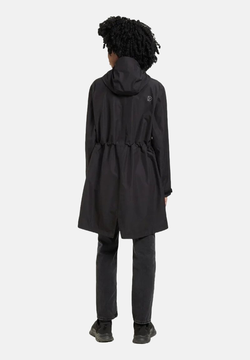 Schwarze leichte Regenjacke mit Kapuze, tailliertem Schnitt und Logo-Detail auf der Rückseite. Kombiniert mit schwarzen Hosen und Schuhen, von hinten gezeigt.