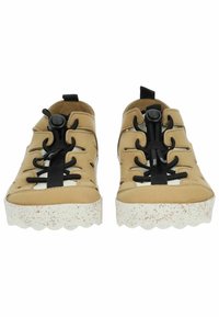 Béžové casual boty s černými elastickými tkaničkami a uzávěrem na doraz, s texturovanou bílou podrážkou s tečkami a vyřezávanými designovými prvky.