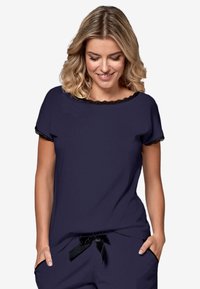 Granatowa bluzka z krótkimi rękawami, wykończona koronką na dekolcie i rękawach, wykonana z miękkiego materiału. Połączona z pasującymi spodniami z detalem w postaci wstążki.