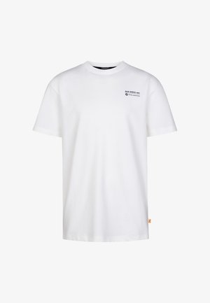 Biała bawełniana koszulka z małym logo, zielone szorty z podwiniętymi brzegami oraz białe trampki z czarnymi akcentami. Czarne skarpetki z dwoma białymi paskami.