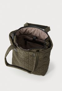 Gequilted olijfgroene tote bag met bovenrits, twee handvatten en een beige interieur met een ritsvak en organisatiecompartimenten.