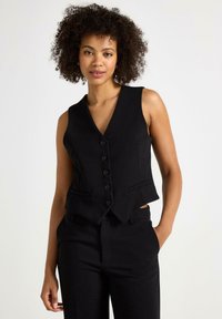 Gilet nero senza maniche con scollatura a V, chiusura a cinque bottoni e due tasche frontali. Vestibilità slim con una forma strutturata e una texture di tessuto liscia.