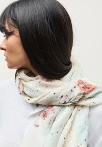 Kerge, lillemustriga sall pastelltoonides kuldsete täppidega. Kujundatud pehme tekstuuri ja ristkülikukujulisena.