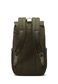 Olivgrüner Rucksack mit verstellbaren Schulterriemen, Obergriff und einem Reißverschlussfach. Hergestellt aus strapazierfähigem Material und mit einem klaren, minimalistischen Design.