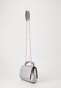 Bolso de mano de cuero plateado con forma estructurada, opciones de transporte dual: asa corta y correa de cadena larga. Presenta un acabado texturizado y una solapa frontal.