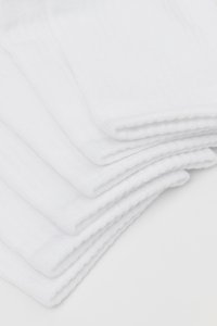 Weiße Baumwollsocken ordentlich gestapelt, mit geriffelter Textur und weichem Finish. Jeder Socke hat ein Standard-Design in Crew-Länge.