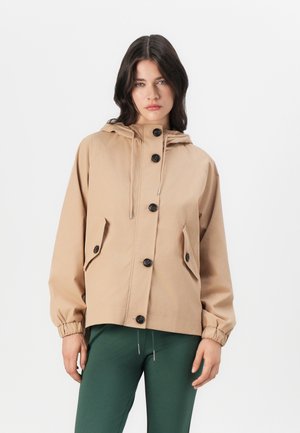 Veste beige à capuche avec des poignets élastiques, cinq boutons noirs et deux poches avant. Tissu lisse avec une coupe décontractée.
