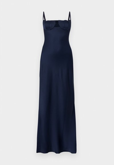 Dziļi zila grīdas garuma kleita ar plānām plecu lencītēm, pieguļošu krūšu daļu ar šuvju detaļām un gludu, plūstošu svārku.