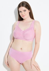 Set di lingerie rosa chiaro con reggiseno decorato con pizzi e una mutanda alta abbinata, entrambi con una texture morbida e un dettaglio a fiocco.