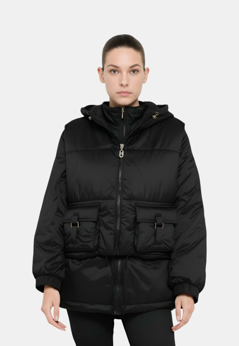 Giubbotto puffato nero con cappuccio, caratterizzato da texture trapuntata, chiusura con zip, due tasche frontali con dettagli dorati e polsini elastici.