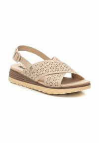 Sándala beige con un patrón floral recortado y tira trasera. Cuenta con una plantilla acolchada y una suela de cuña con un detalle texturizado en marrón claro.
