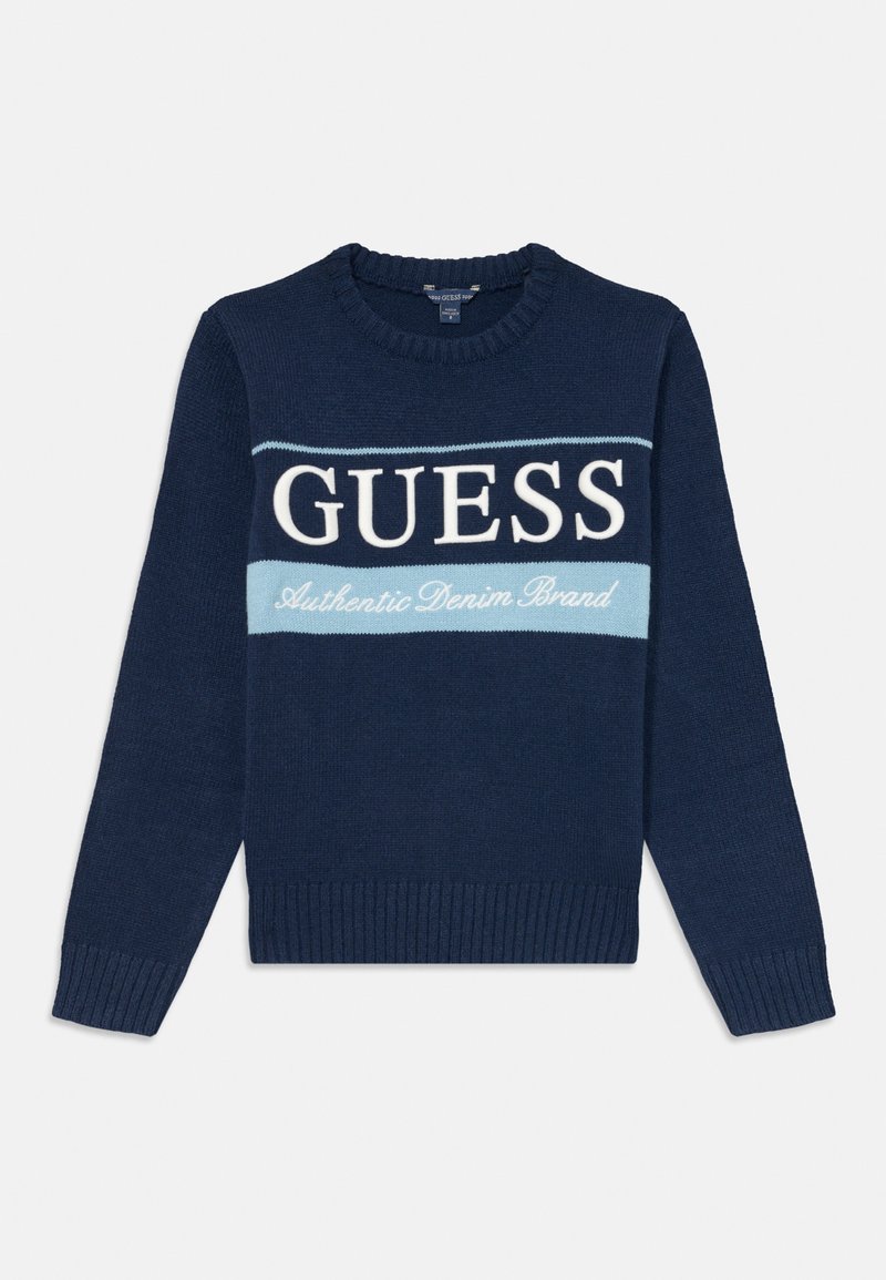Suéter tricotado azul-marinho com gola careca, apresentando um acabamento canelado na barra e punhos, e texto gráfico "GUESS" e "Authentic Denim Brand" em branco e azul-claro.