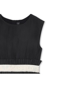 Μαύρο πλισέ φόρεμα με στρογγυλή λαιμόκοψη. Διαθέτει υφασμάτινη ζώνη με ανάγλυφη επιγραφή "KARL LAGERFELD" σε αντίθετο ανοιχτό χρώμα.