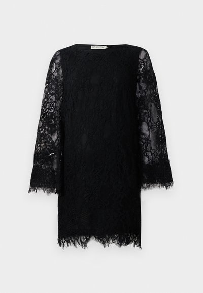 Melna mežģīņu mini kleita ar garām caurspīdīgām ziedu mežģīņu piedurknēm un viļņotu apakšmalu, ar apaļu kakla izgriezumu.