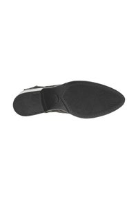 Semelle en caoutchouc noir d'une chaussure, avec un motif texturé, un bout légèrement pointu et des détails de couture le long des bords.