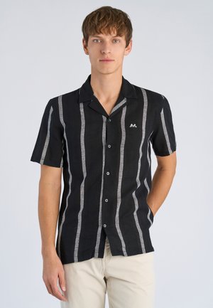 Czarna koszula z krótkim rękawem z pionowymi szarymi paskami, kołnierzykiem, zapięciem na guziki z przodu oraz małym białym logo po lewej stronie.