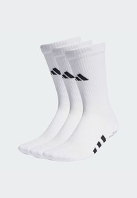 Tres pares de calcetines blancos con puños acanalados, que cuentan con un logo negro y acentos a rayas en las suelas. Están hechos de una tela suave y elástica.
