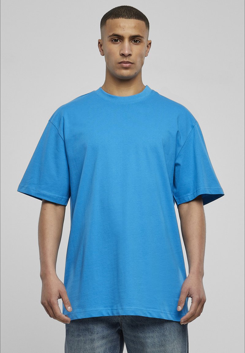 Tricou oversized din bumbac albastru, cu mâneci scurte, guler rotund și croială relaxată. Textură netedă, fără modele sau accente.