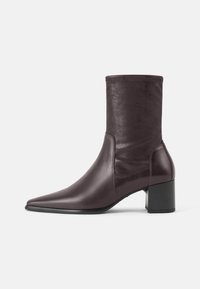 Bordeauxrode enkellaars gemaakt van glanzend materiaal, met een puntige neus en een stevige zwarte blokhak, voorzien van een aansluitende schacht.