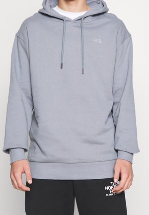 Sweat-shirt à capuche gris avec une coupe ample, poignets et ourlet côtelés, arborant un logo et des cordons de serrage avec des embouts métalliques. Matière douce en mélange de coton.
