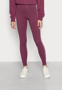 Deep burgundy leggings made of stretchy material, featuring a slim fit and contrasting light pink side stripes, with an elastic waistband.