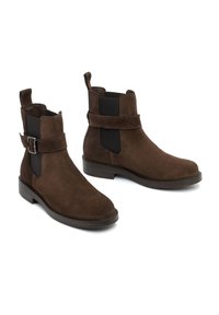 Brown suede ankle boots with elastic side panels, buckle accent, and textured surface. Low heel and rounded toe design.