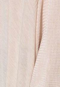 Tessuto beige chiaro con una trama morbida e testurizzata. Presenta strisce orizzontali e verticali che creano un motivo sottile, con una finitura liscia.