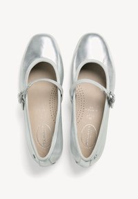 Zilveren metallic balletschoenen met een ronde neus, een verstelbaar bandje met een kleine gesp en een lichtgevoerd interieur.
