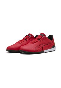 Zapatillas deportivas sintéticas rojas con un acabado liso, diseño perforado, detalles en negro y suela blanca. Cuentan con cordones y un detalle de logo.