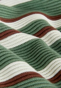 Geribbelde textiel met afwisselend groene, crèmekleurige en bruine strepen. Het patroon vertoont golvende lijnen die textuur aan de stof geven.