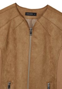 Giacca in suede marrone con zip argentata frontale e due tasche con zip, collo rotondo e etichetta nera che mostra il marchio e la taglia piccola.