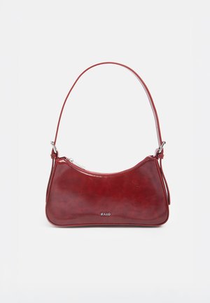 Petit sac à bandoulière en cuir rouge foncé brillant avec fermeture éclair argentée et logo "RAID" sur le devant sur fond blanc.