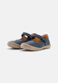 Zapatos de cuero azul oscuro con una correa de velcro, punta redondeada y suela de goma ligera. Diseño decorativo perforado a lo largo de los bordes.
