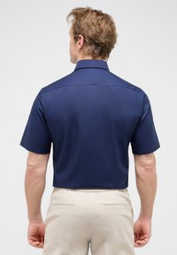 Korte mouwen overhemd in marineblauw, van gladde stof. Met kraagontwerp, een achterpand en een nette afwerking. Gecombineerd met beige broek.